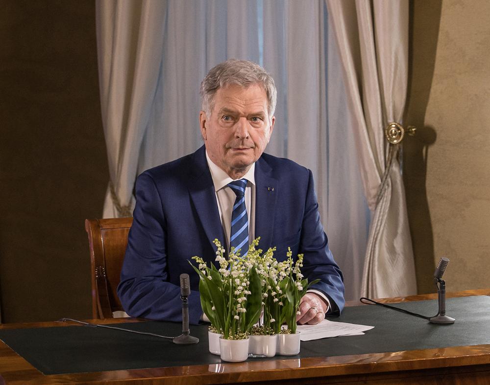 Presidentti Sauli Niinistö istuu työpöydän ääressä.