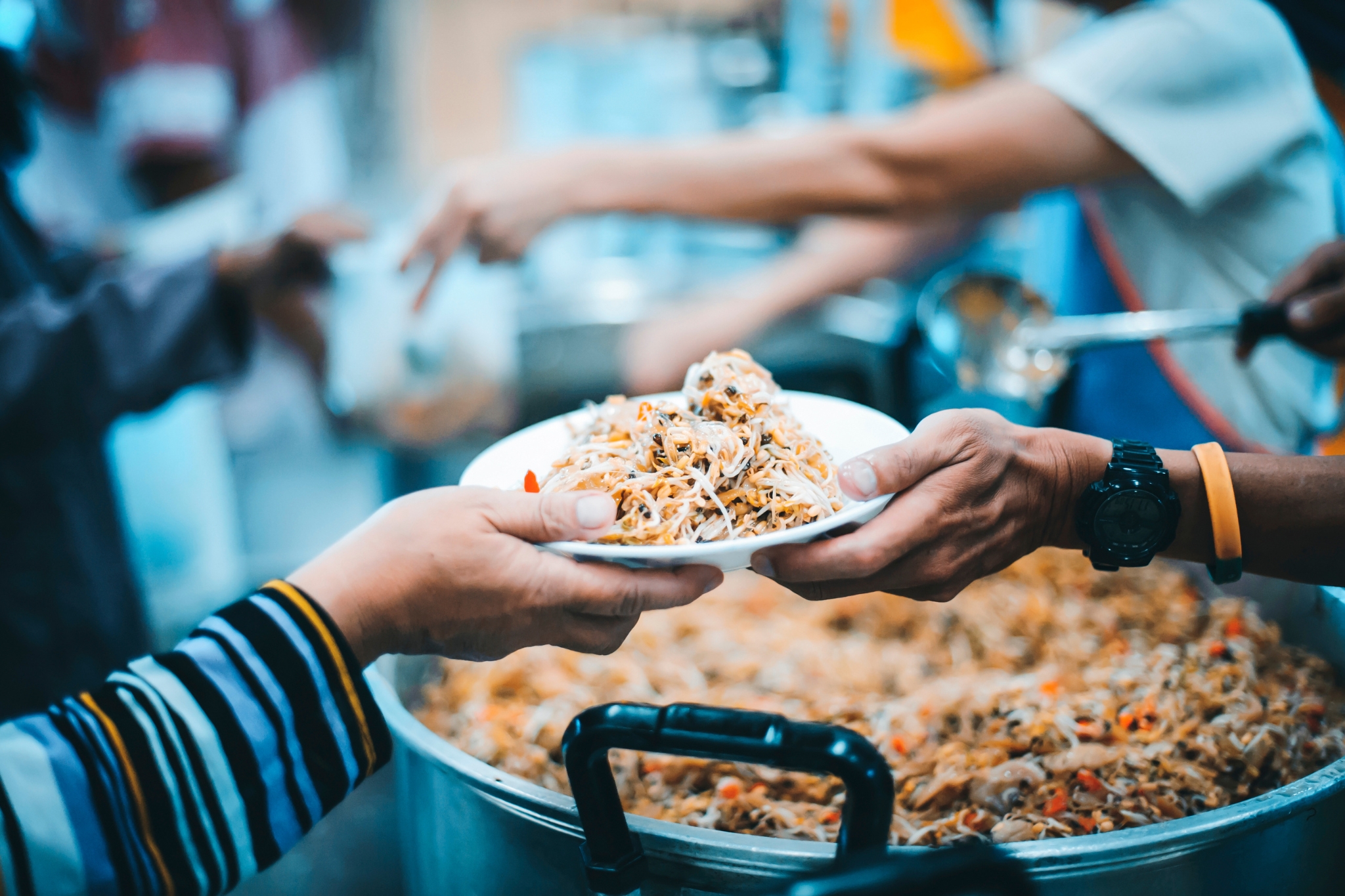 Kädet jakamassa ruokalautasta