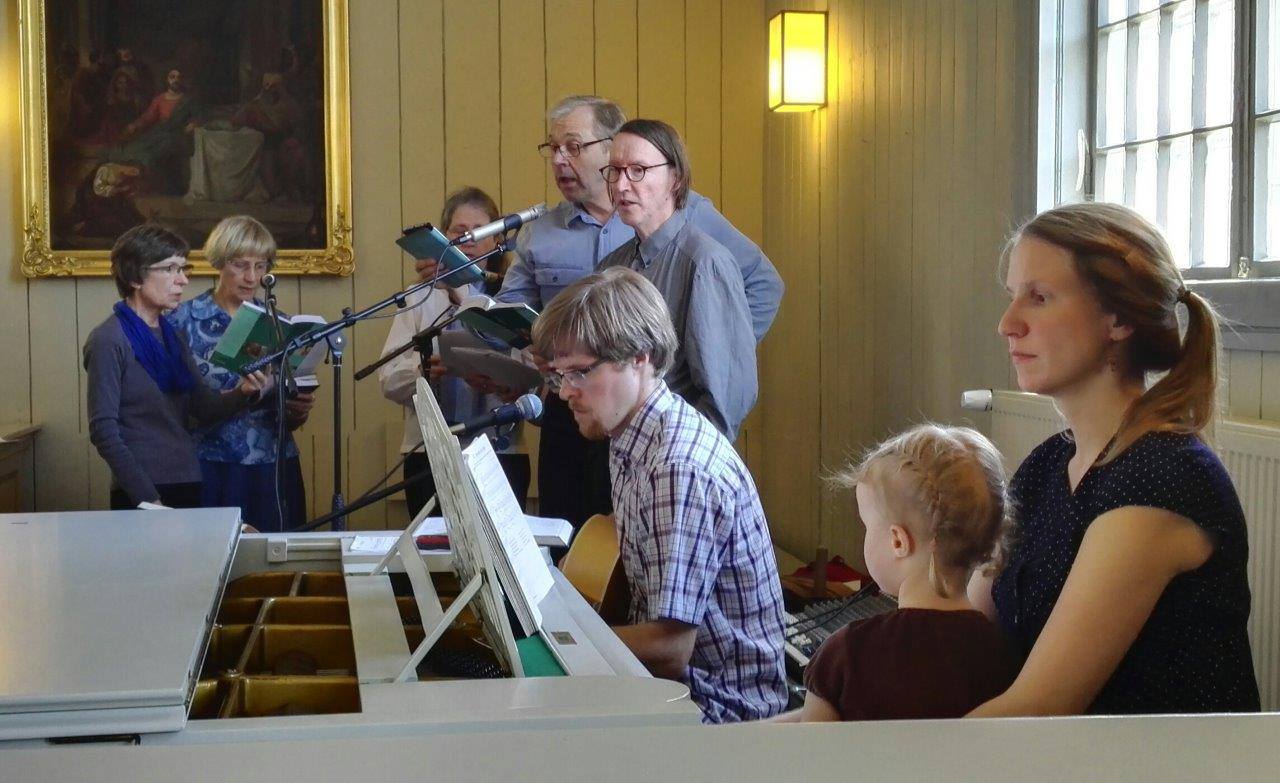 Monta ihmistä kirkossa laulamassa.