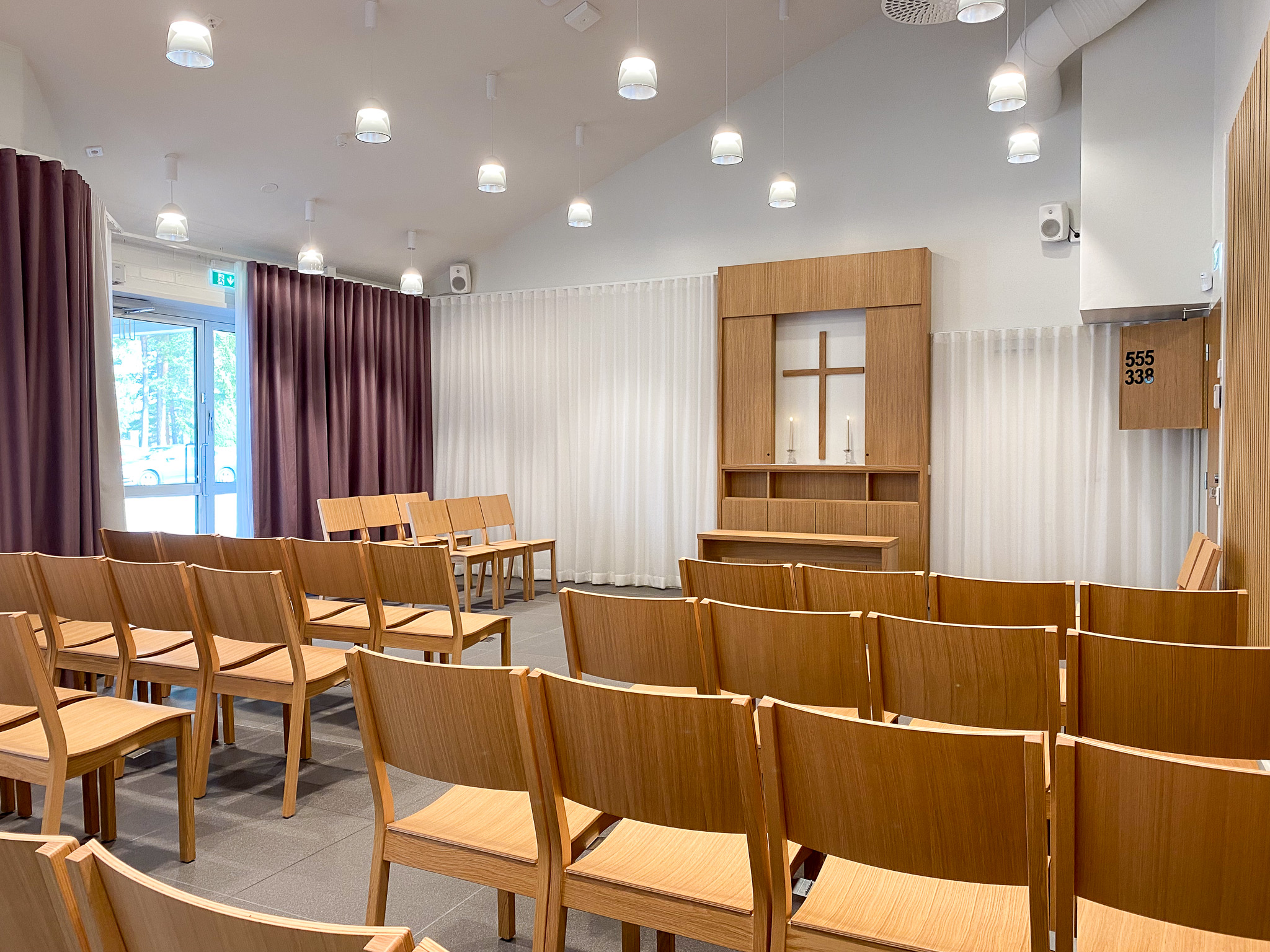 Aeternitas-kappeli hautausmaan päärakennuksessa Kappelitila puutuolit riveissä.