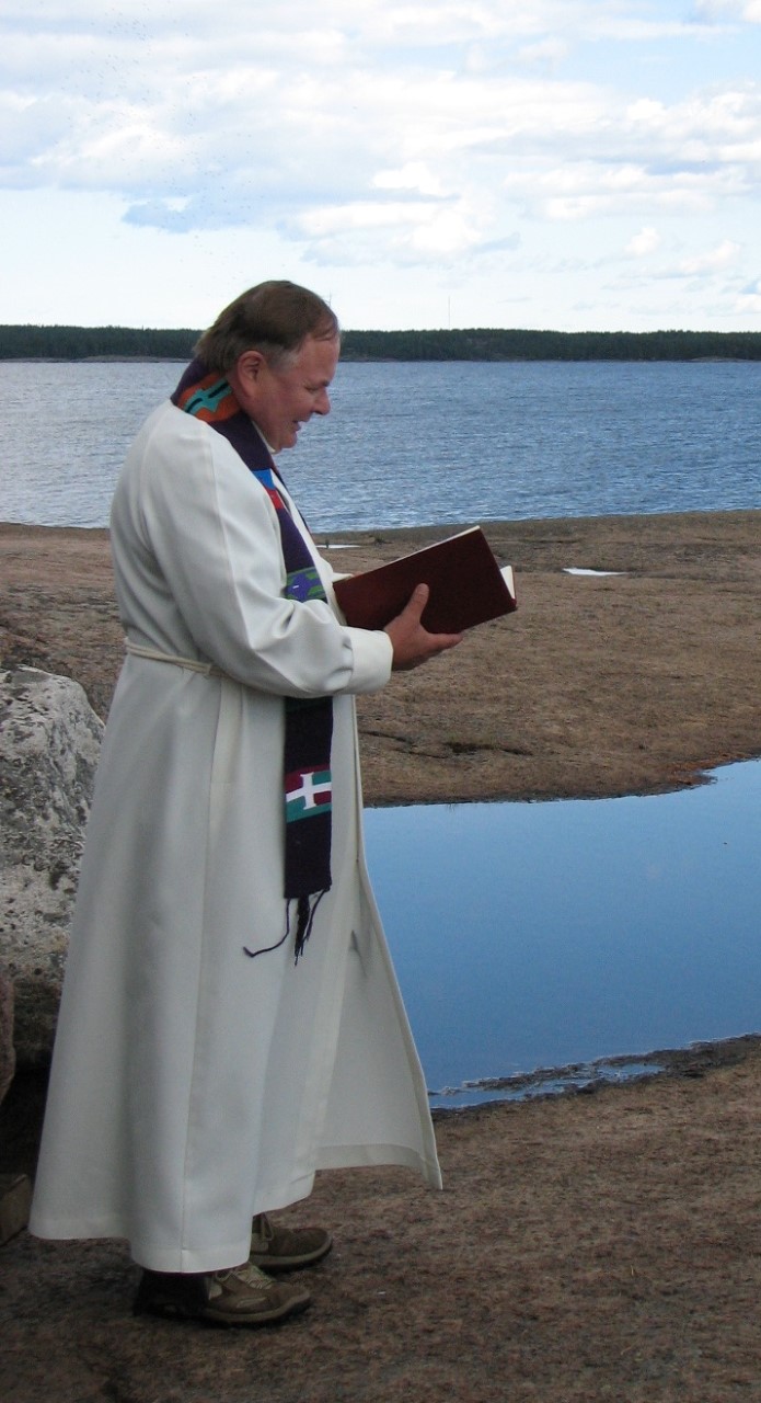 pappi saarnaa meren äärellä